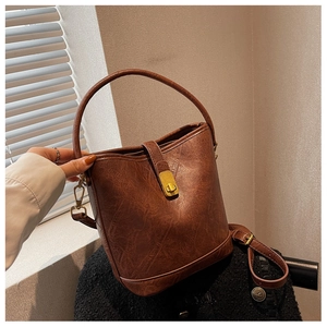 Detail of vintage brown bucket bag with crackle texture leather and gold metal clasp