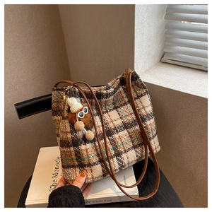 Close-up of retro plaid canvas tote bag in brown and beige with a cute bear charm