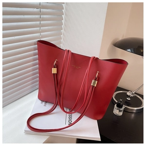 Detail of red leather tote bag showing fine texture and elegant gold metallic hardware