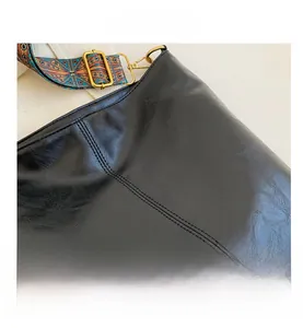 Dettaglio della trama in pelle PU nera con tracolla colorata in stile bohémien