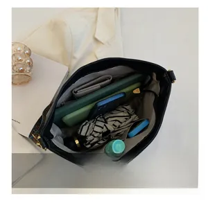 Interno spazioso di una borsa tote in pelle nera con tablet, telefono e ombrello