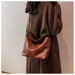 Dettaglio borsa tote in pelle marrone retrò con ampia tracolla con motivo etnico chic