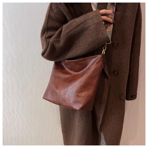 Dettaglio della borsa tote vintage in pelle marrone con tracolla jacquard etnica