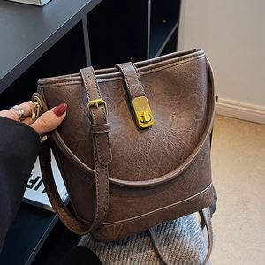 Brown bucket bag in wrinkled leather with a vintage gold clasp and top handle strap