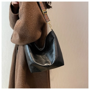 Dettaglio della borsa in ecopelle nera con ampia tracolla jacquard stile bohémien