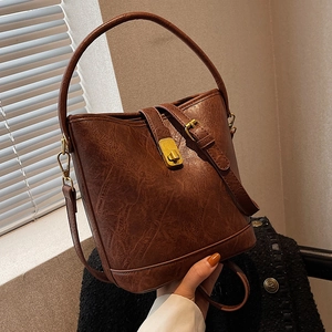 Brown vintage leather bucket bag with gold metal clasp and adjustable shoulder strap