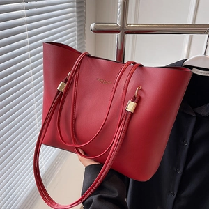 Large red leather tote bag with gold lettering and shoulder strap for daily commuting