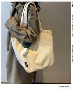 Canvas tote bag in beige with shoulder strap and a cute scalloped plush green pendant