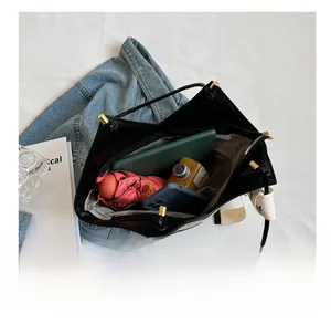 Interior view showing the large capacity of the black PU tote bag with daily essentials