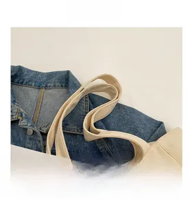 Detail of reinforced shoulder straps on a creamy white canvas tote bag for women