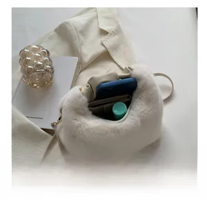 Detailed interior view showing storage capacity for phone and wallet in plush crossbody bag