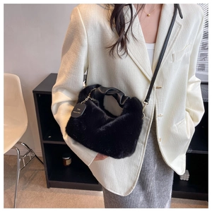 Détail du sac à main en fausse fourrure noire avec poignée en cuir froncé et étiquette