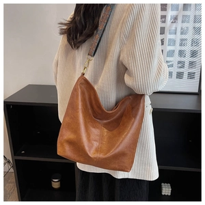 Dettaglio borsa hobo marrone con ampia tracolla ricamata in stile etnico retrò