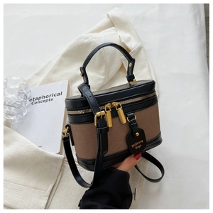 Dettaglio mini borsa a secchiello vintage in tela marrone con finiture in pelle nera