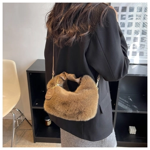 Detailed back view of a plush brown faux fur shoulder bag with knotted handle and chain