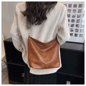 Brown retro hobo bag detail with patterned wide strap and vintage brass hardware