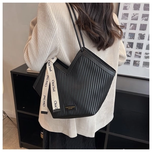 Detail of black pleated PU shoulder bag with decorative lettered strap and logo patch