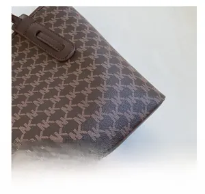 Detail showing high-quality coffee brown faux leather and signature NK logo pattern