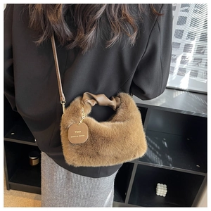 Detailed close-up of brown plush faux fur handbag with a leather tag and gold chain detail