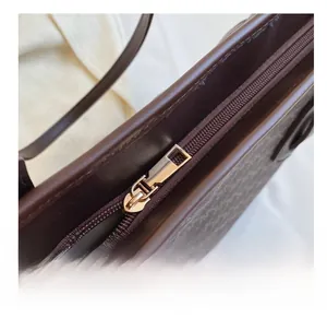 Close-up of smooth gold zipper detail and vintage pattern on large tote bag