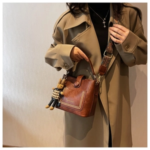 Brown leather bucket bag with vintage printed strap and cute rabbit charm detail
