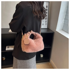 Détail du sac à bandoulière en fausse fourrure rose avec poignée en cuir plissé doré