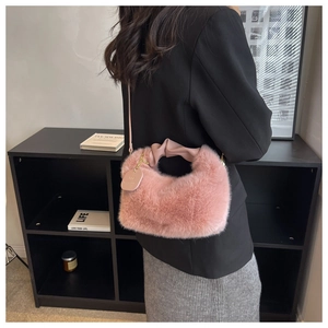 Détail d'un sac porté épaule en fausse fourrure rose avec poignée en cuir souple