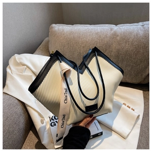 Detail of pleated tote bag with black leather trim and Chia'2nd woven decorative strap