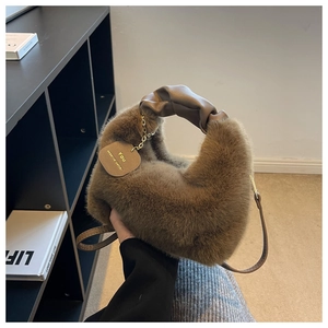 Gros plan détaillé du sac à main en peluche marron foncé avec anse en cuir et chaîne