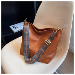 Detail of a brown leather Hobo bag featuring a vintage jacquard ethnic pattern wide strap