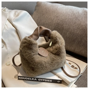 Détail d'un sac à main en peluche marron avec poignée en cuir torsadée et étiquette