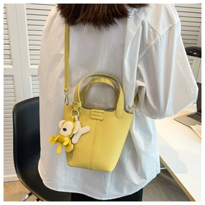 Detailansicht der gelben Beuteltasche mit Litschi-Struktur und FASHION-Logo