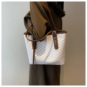Detail shot of large capacity tote bag featuring NK monogram pattern and brown leather straps