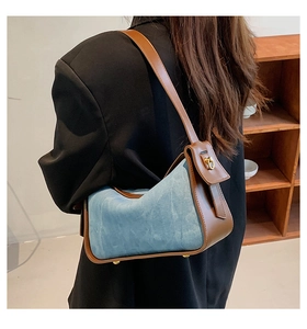 Detail of a vintage two-tone shoulder bag featuring blue suede and brown leather trim