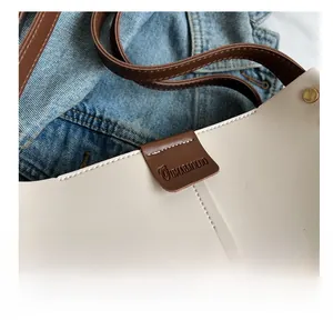 Close-up of precise stitching on the cream and brown leather large capacity tote bag