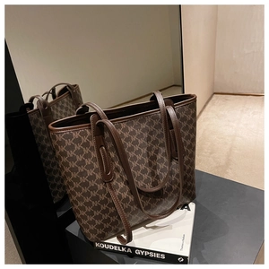 Classic dark brown monogram pattern on large tote bag with leather straps and art book