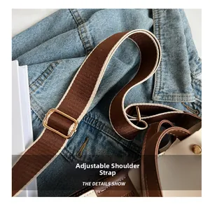 Detail of adjustable woven canvas shoulder strap with gold-tone hardware on a tote bag