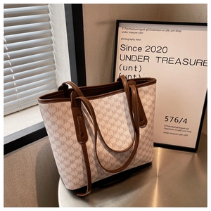 Macro view of canvas tote bag with letter pattern and premium brown leather handle detail