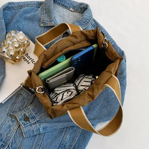 Interior espacioso del bolso tote de nailon acolchado marrón con correa ancha de tela