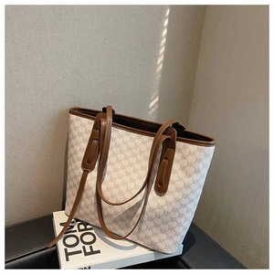 Macro detail of monogram pattern on oversized tote bag with brown leather contrast trim
