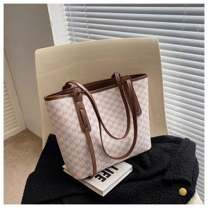 Detail of large tote bag with brown NK pattern on white chair with life magazine