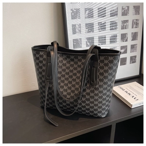 Detailed view of large tote bag featuring classic monogram pattern and slim straps