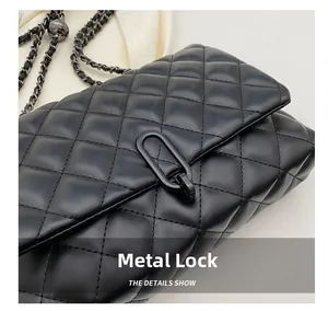 Detailed macro view of matte black hardware clasp on a quilted rhombic chain shoulder bag