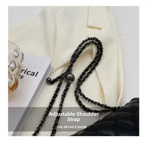 Detail of black quilted leather bag featuring a gold chain strap with adjustable metal ball buckle