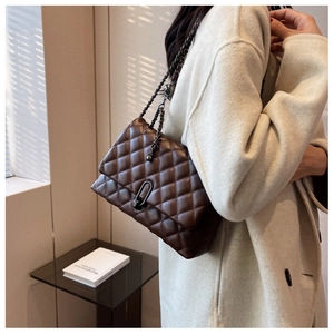 Close-up of a quilted dark brown shoulder bag with an oval twist lock and chain strap
