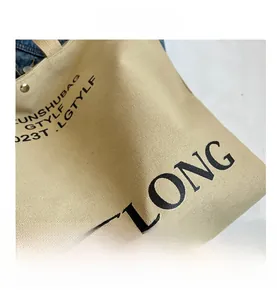 Close-up of durable beige canvas tote bag with black minimalist typography and coarse texture