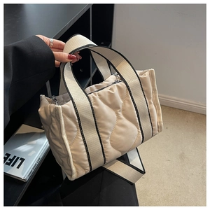 Detalle del bolso tote de nailon acolchado con correa ancha en contraste y cremallera