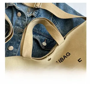 Detail of reinforced wide canvas handle on beige tote bag with black letter design