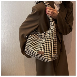 Detail of black and white houndstooth pattern fabric on a large hobo shoulder bag
