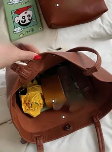 Detail view of brown pebbled leather tote bag showing spacious interior and magnetic closure